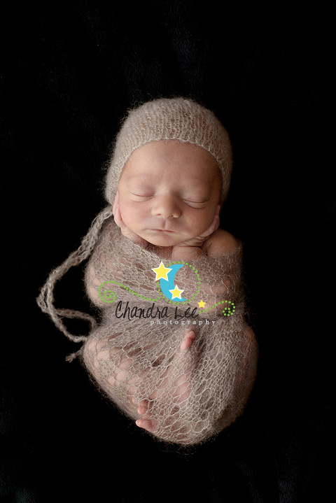 Picture of Toronto baby on black background with bonnet in wrap