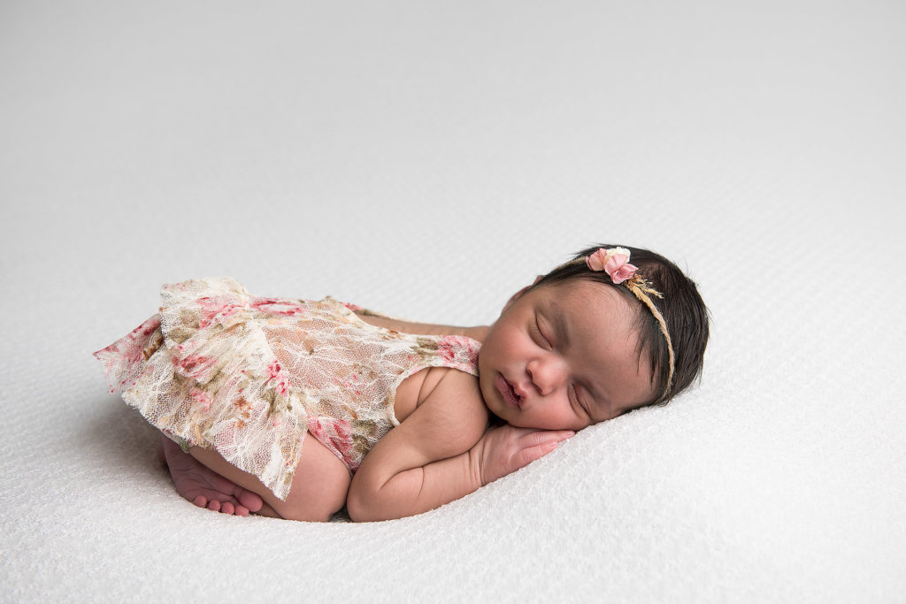 Baby-sleeping-on-tummy-in-lace-flower-outfit
