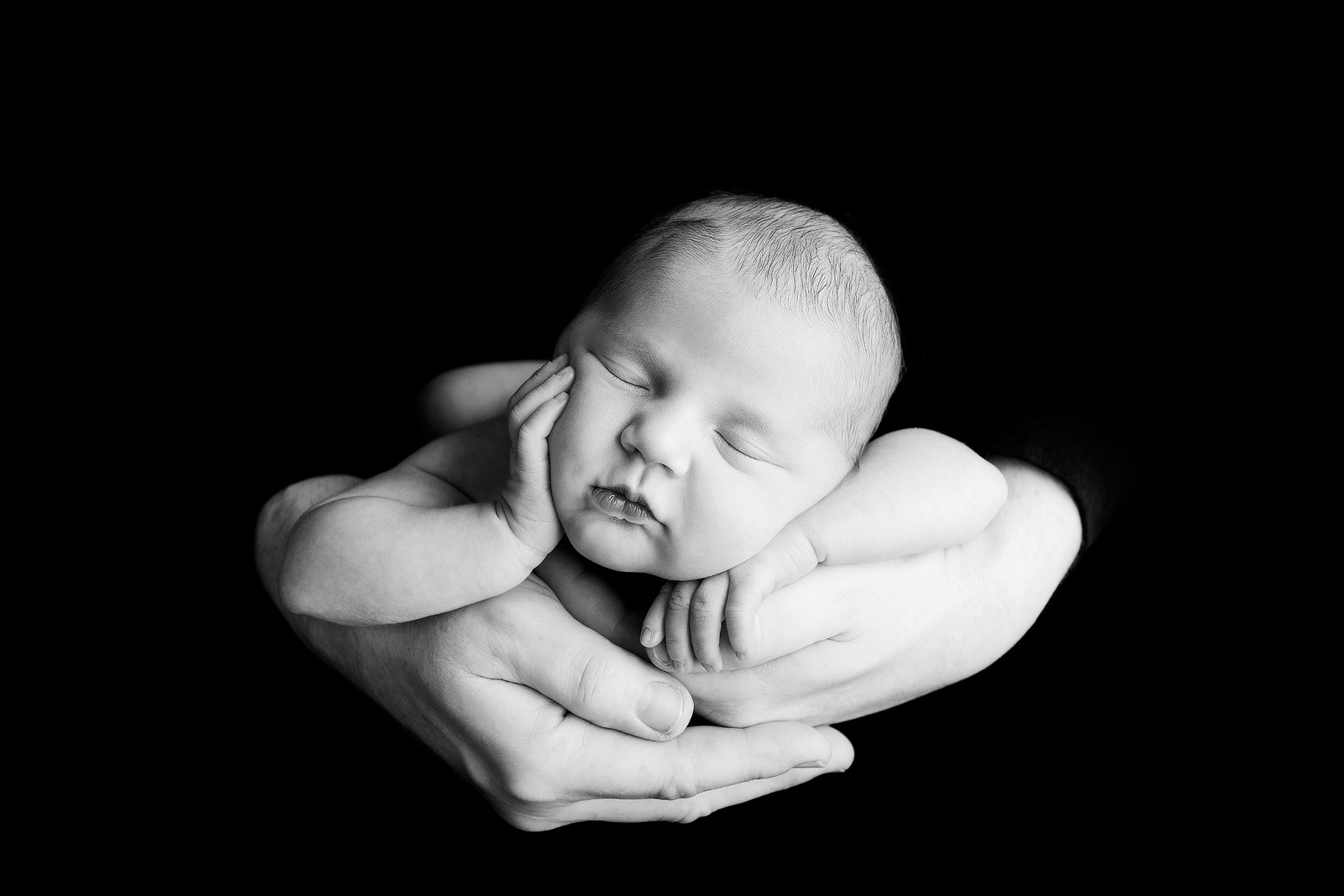 Photography-of-Albany-as-a-newborn-in-dads-hands