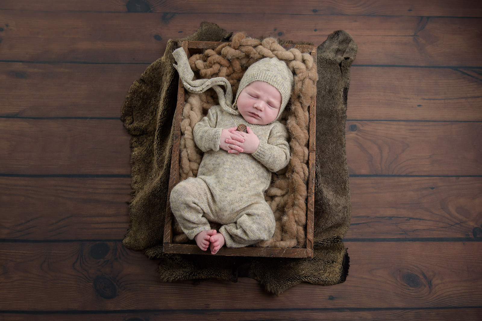 newborn-boy-in-crate-and-brown-colour-setup